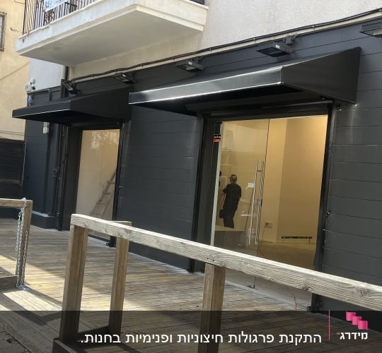 שני סוככים שחורים מעל דלתות זכוכית בחזית חנות